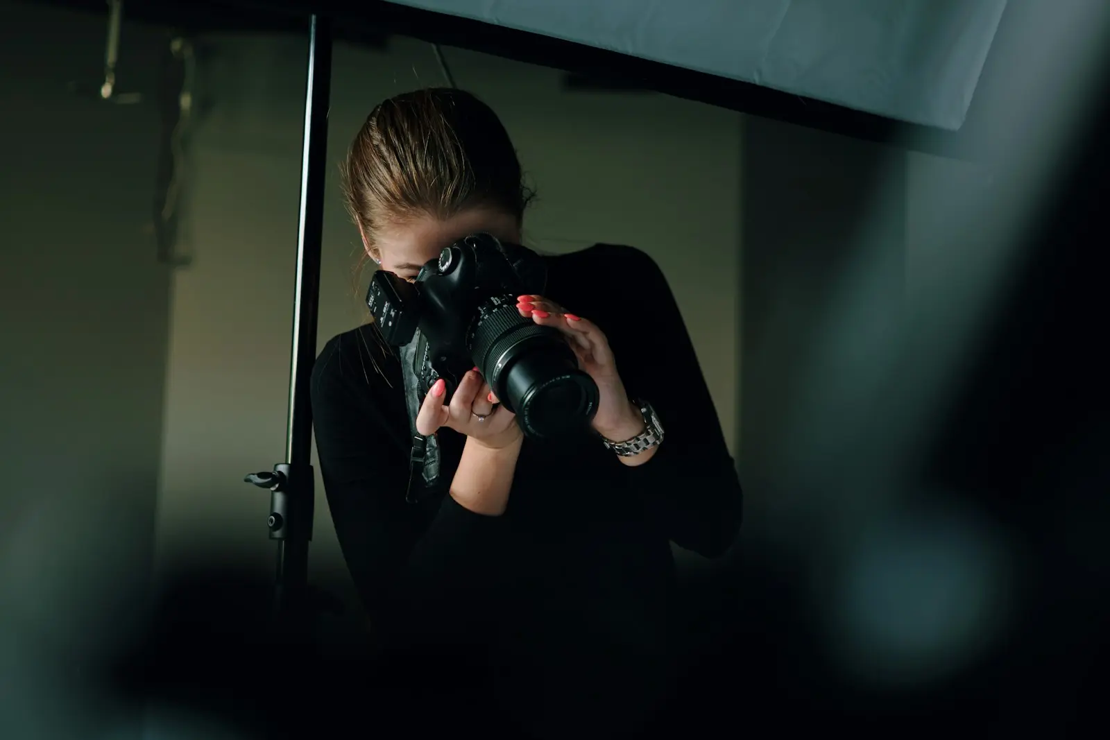 Fotografin mit Kamera im Studio unter einer Softbox