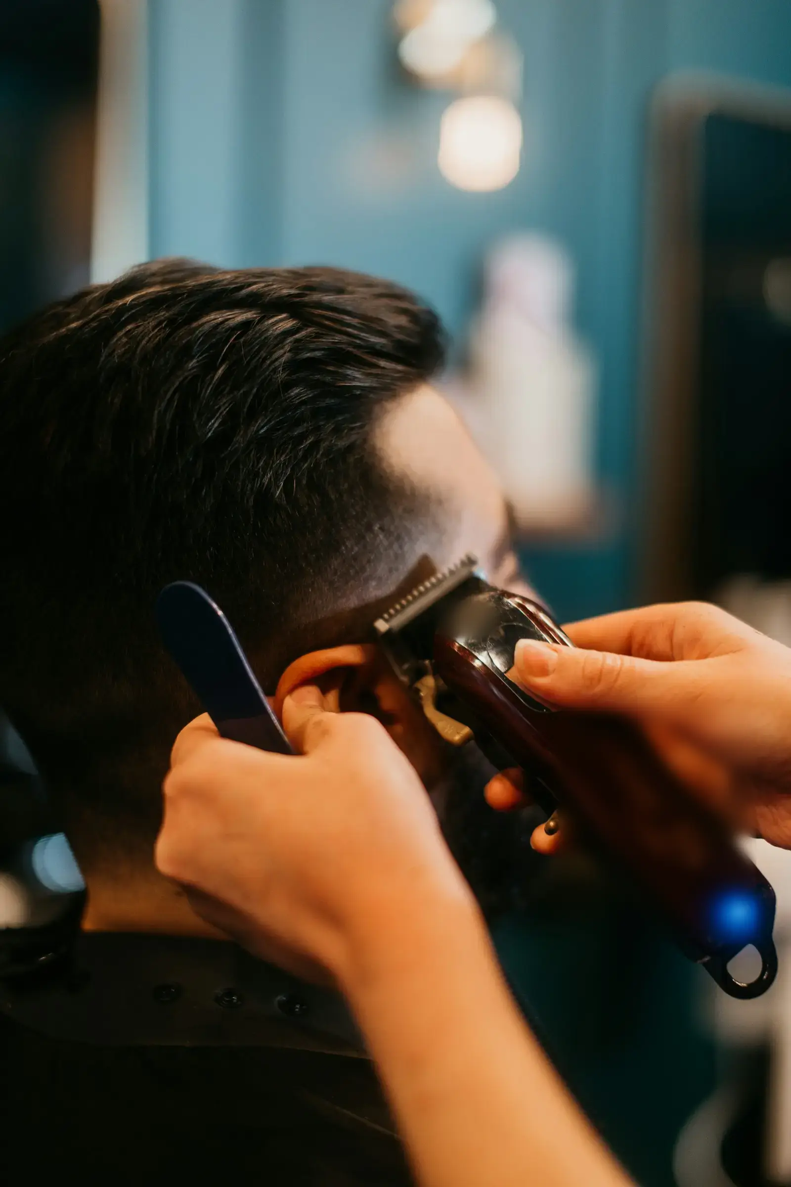 Friseur schneidet einem Kunden die Haare mit der Maschine